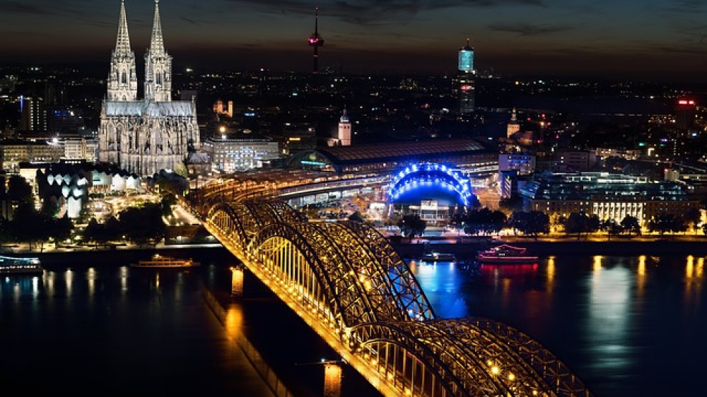 Blick auf das nächtliche Köln (Symbolbild). Hier wird künftig die Zurich Gruppe Deutschland ihre beiden Standorte Köln und Bonn bündeln.