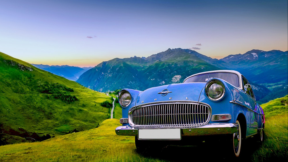 Ein Opel-Oldtimer vor idyllischer Landschaft (Symbolbild). Bei dem Rüsselsheimer Autobauer ging es zuletzt weniger idyllisch zu.